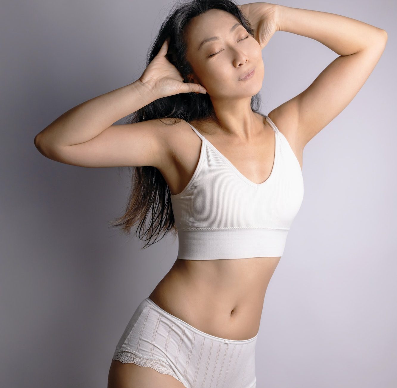 Asian woman in great shape, perfect body shape. Parts of a female body in underwear, studio shot.