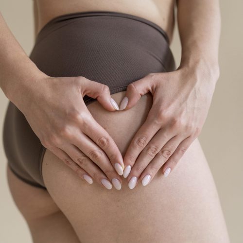 Close up hands making heart gesture on thigh